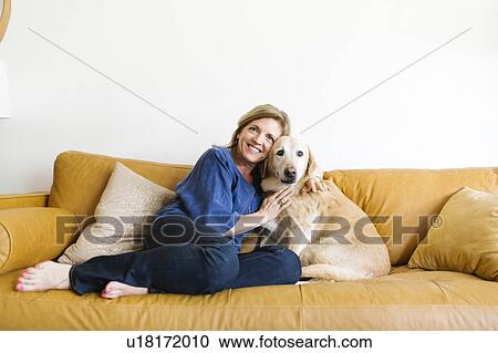 Portrait of woman embracing Labrador Retriever on sofa View Large Photo Image Stock Image - Portrait of woman embracing Labrador Retriever on sofa. Fotosearch
