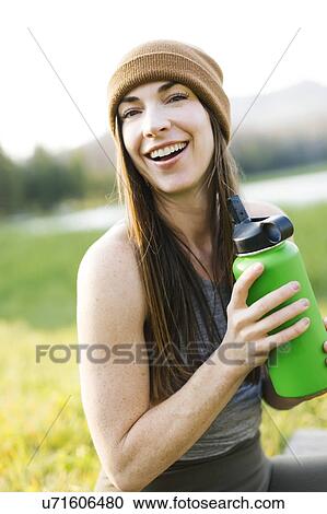 Stock Image - Portrait of woman holding water bottle. Fotosearch