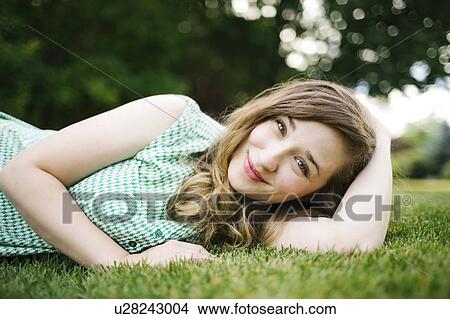 Portrait of woman lying on grass and smiling View Large Photo Image Picture - Portrait of woman lying on grass and smiling. Fotosearch