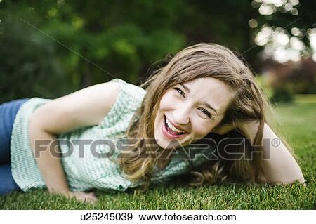 Portrait of woman lying on grass and laughing View Large Photo Image Stock Photo - Portrait of woman lying on grass and laughing. Fotosearch