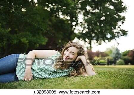 Portrait of woman lying on grass View Large Photo Image Stock Photography - Portrait of woman lying on grass. Fotosearch