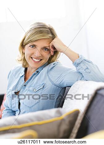 Portrait of woman sitting on sofa View Large Photo Image Stock Image - Portrait of woman sitting on sofa. Fotosearch