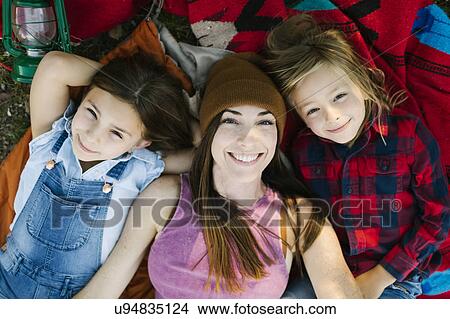 Picture - Portrait of woman with son (6-7) and daughter (8-9) lying on blanket. Fotosearch