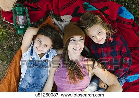 Portrait of woman with son (6-7) and daughter (8-9) lying on blanket View Large Photo Image Stock Photo - Portrait of woman with son (6-7) and daughter (8-9) lying on blanket. Fotosearch