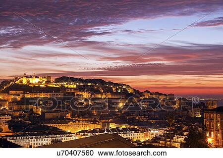 Stock Image - Portugal, Lisbon, Saint George's Castle above Old Town in Lisbon at dusk. Fotosearch