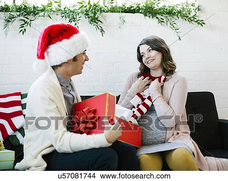 Picture - Pregnant woman receiving christmas present. Fotosearch