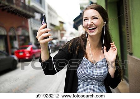 Stock Image - Puerto Rico, San Juan, Woman listening to music on street. Fotosearch