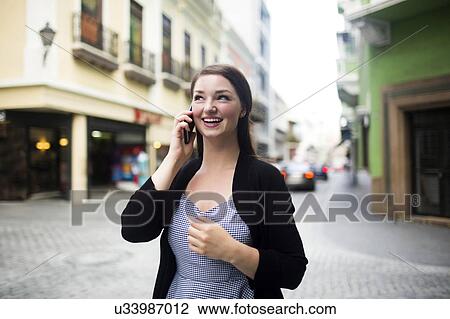 Stock Image - Puerto Rico, San Juan, woman on square talking on smartphone. Fotosearch
