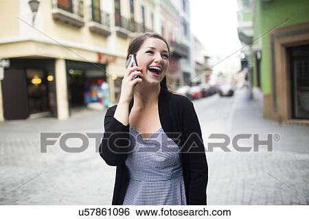 Stock Photograph - Puerto Rico, San Juan, woman on square talking on smartphone. Fotosearch
