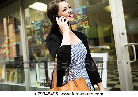 Puerto Rico, San Juan, Woman walking on street and talking on mobile phone View Large Photo Image Stock Photography - Puerto Rico, San Juan, Woman walking on street and talking on mobile phone. Fotosearch