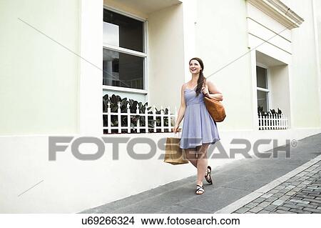 Picture - Puerto Rico, San Juan, Woman with shopping bag walking city streets. Fotosearch