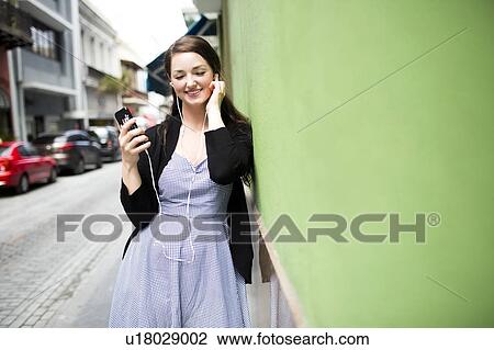 Puerto Rico, San Juan, woman with smartphone and earphones on street View Large Photo Image Stock Image - Puerto Rico, San Juan, woman with smartphone and earphones on street. Fotosearch