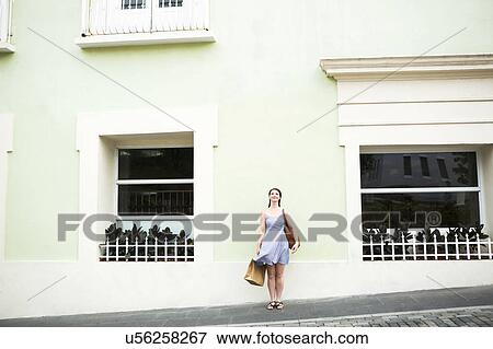Stock Photo - Puerto Rico, San Juan, Woman with shopping bag walking city streets. Fotosearch