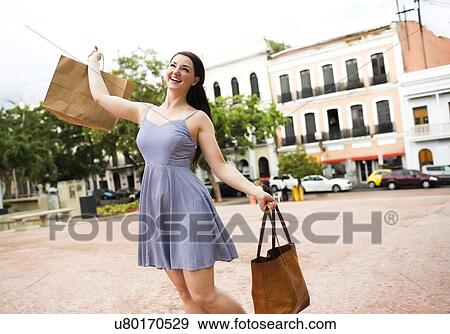 Stock Photo - Puerto Rico, San Juan, Woman with shopping bag walking city streets. Fotosearch
