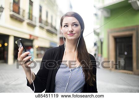 Puerto Rico, San Juan, woman with smartphone and earphones on street View Large Photo Image Stock Photo - Puerto Rico, San Juan, woman with smartphone and earphones on street. Fotosearch