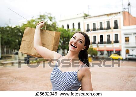 Stock Photograph - Puerto Rico, San Juan, Woman with shopping bag walking city streets. Fotosearch