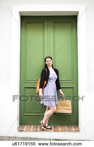 Puerto Rico, San Juan, Woman with shopping bag standing in front of green door View Large Photo Image Stock Photography - Puerto Rico, San Juan, Woman with shopping bag standing in front of green door. Fotosearch