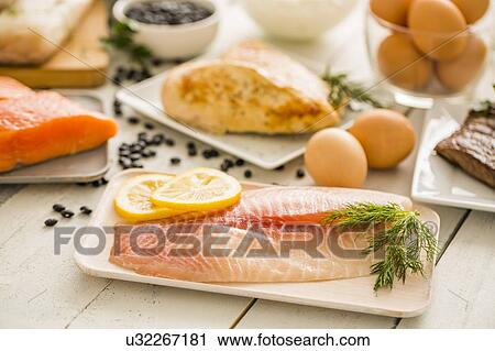 Raw tilapia fish on plate, chicken and eggs in background View Large Photo Image Stock Image - Raw tilapia fish on plate, chicken and eggs in background. Fotosearch