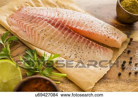 Raw tilapia on cutting board View Large Photo Image Picture - Raw tilapia on cutting board. Fotosearch