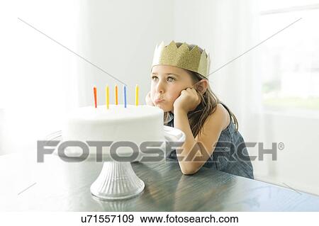 Sad girl (6-7) with birthday cake View Large Photo Image Stock Photo - Sad girl (6-7) with birthday cake. Fotosearch