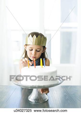 Stock Photography - Sad girl (6-7) with birthday cake. Fotosearch