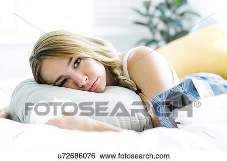 Sad young woman lying on bed and crying View Large Photo Image Stock Photograph - Sad young woman lying on bed and crying. Fotosearch