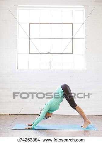 Picture - Senior woman practicing yoga on mat. Fotosearch