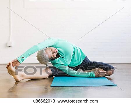 Senior woman practicing yoga on mat View Large Photo Image Stock Image - Senior woman practicing yoga on mat. Fotosearch