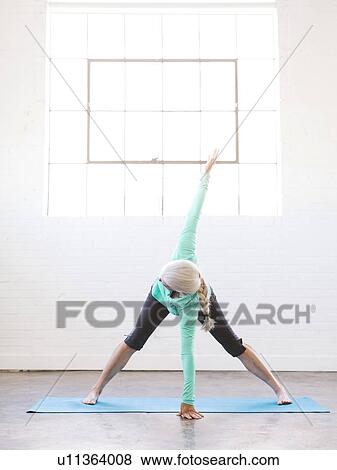 Stock Photo - Senior woman practicing yoga on mat. Fotosearch