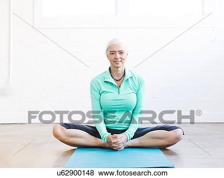 Senior woman practicing yoga on mat View Large Photo Image Stock Photo - Senior woman practicing yoga on mat. Fotosearch