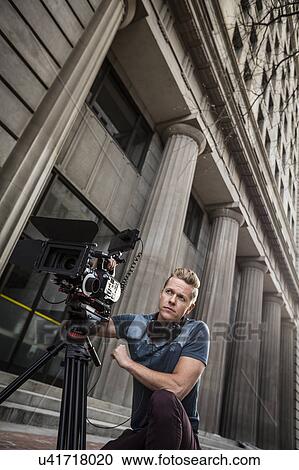 Stock Image - Serious camera operator looking away. Fotosearch
