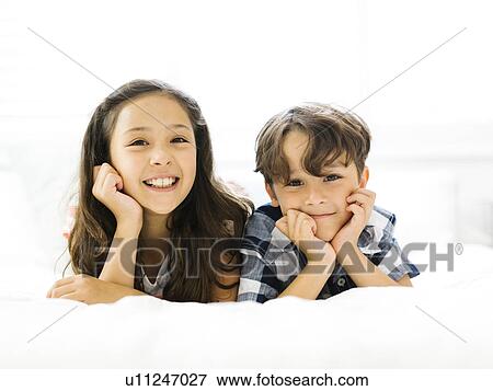 Siblings (10-11, 6-7) lying in bed side by side View Large Photo Image Stock Photo - Siblings (10-11, 6-7) lying in bed side by side. Fotosearch