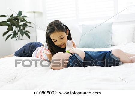 Sister ( 10-11 ) feeding brother ( 2-5 months ) with baby bottle View Large Photo Image Stock Image - Sister ( 10-11 ) feeding brother ( 2-5 months ) with baby bottle. Fotosearch