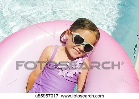 Smiling girl (4-5) relaxing in inflatable ring View Large Photo Image Stock Photo - Smiling girl (4-5) relaxing in inflatable ring. Fotosearch