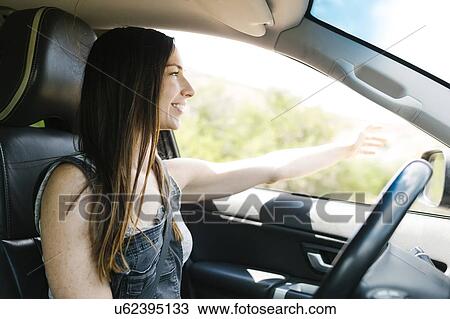 Stock Image - Smiling woman driving car. Fotosearch