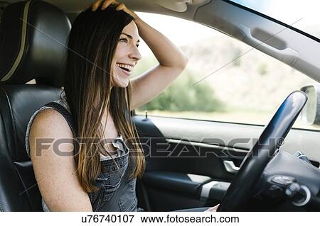 Stock Photo - Smiling woman driving car. Fotosearch