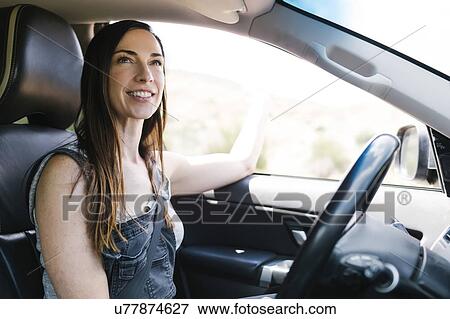 Stock Photo - Smiling woman driving car. Fotosearch