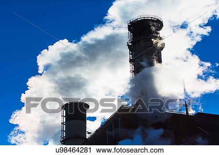 Stock Image - Smokestack releasing smoke. Fotosearch