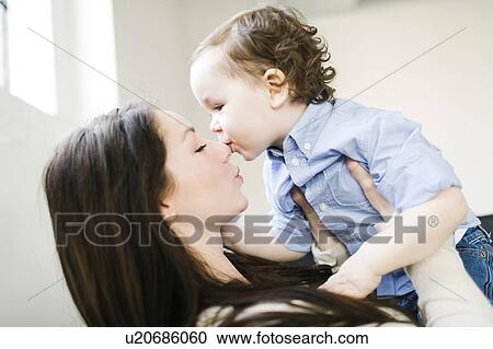 Stock Image - Son (4-5) kissing mother's nose. Fotosearch