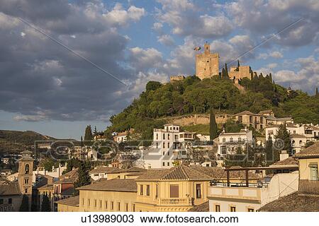 Stock Image - Spain, Andalusia, Granada, Plaza Nueva, Palace of Alhambra on hill. Fotosearch