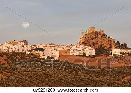 Stock Image - Spain, Andalusia, Olvera, Townscape with moonrise. Fotosearch