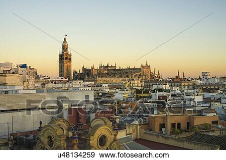 Stock Photo - Spain, Seville, Cityscape with Cathedral of Seville at sunset. Fotosearch