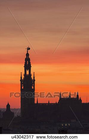 Stock Photo - Spain, Seville, Silhouette of Giralda and Cathedral of Sevilla at sunset. Fotosearch