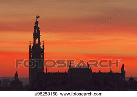 Stock Photo - Spain, Seville, Silhouette of Giralda and Cathedral of Sevilla at sunset. Fotosearch