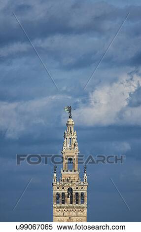 Stock Photography - Spain, Seville, Top of Giralda Tower against clouds. Fotosearch