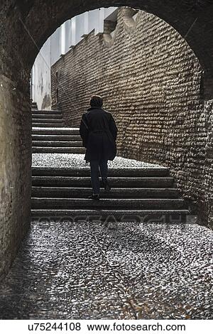 Spain, Seville, Triana, Woman walking through Cajellon De La Inquisicion View Large Photo Image Stock Photo - Spain, Seville, Triana, Woman walking through Cajellon De La Inquisicion. Fotosearch