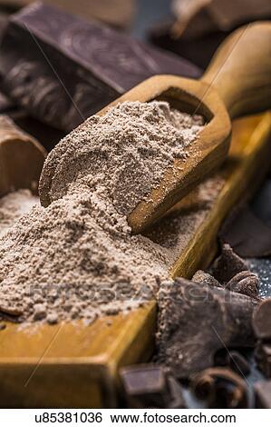 Stock Photograph - Still life with wooden scoop full with chocolate powder. Fotosearch