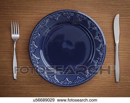 Stock Photo - Studio shot of blue plate with fork and knife. Fotosearch