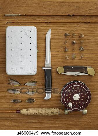 Stock Photo - Studio shot of flyfishing equipment on wooden table. Fotosearch