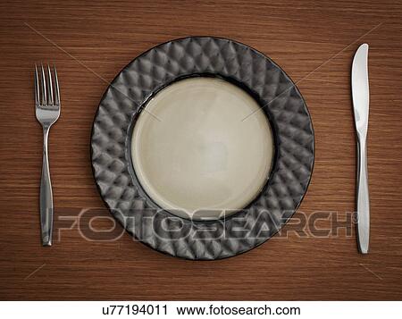 Stock Image - Studio shot of plate with fork and knife. Fotosearch